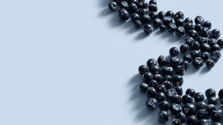 A visually appealing arrangement of fresh blueberries on a smooth blue backdrop. This image highlights the beauty and health benefits of nutritious berries.の素材