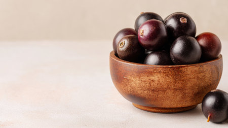 A beautiful composition of fresh dark purple grapes arranged in a wooden bowl, showcasing their rich color and natural texture on a neutral background. Perfect for food enthusiasts.の素材