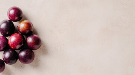 A beautiful arrangement of fresh purple plums on a light, textured surface, offering a vibrant and appealing visual for food enthusiasts and health projects.の素材