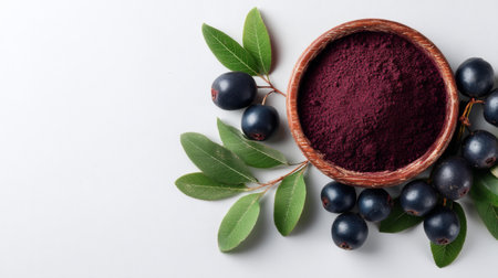 A beautiful arrangement featuring a bowl of organic acai powder alongside fresh acai berries and green leaves, ideal for health and wellness projects showcasing nutrition.の素材