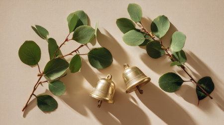 This image features elegant gold bells placed among lush greenery, casting soft shadows on a neutral background, perfect for bringing a tranquil and aesthetic feel to any project.の素材