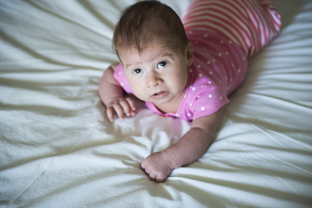 Newborn lying on stomach trying to hold her head