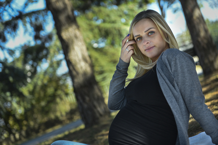 Beautiful young pregnant woman poses in natureの写真素材