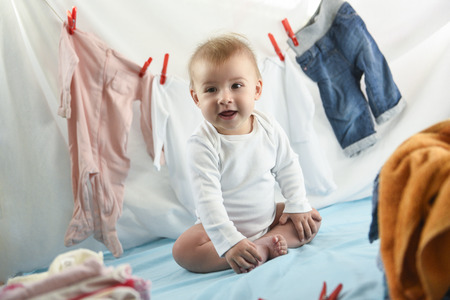 Adorable baby girl with laundry hangingの写真素材