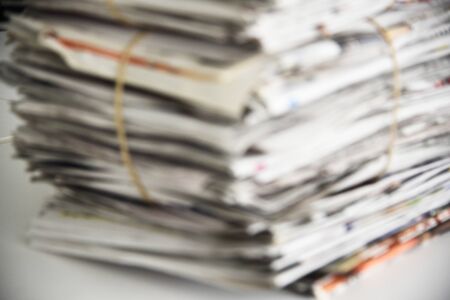 Blurred a pile of newspaper, background texture. Lots of retro journals with headlines, articles and photosの写真素材
