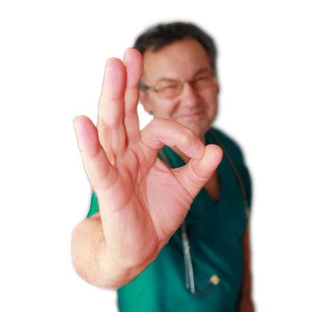 Smiling doctor with okay gesture isolated on white.の写真素材