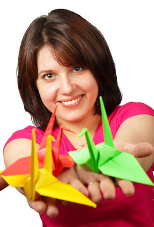 Portrait of a beautiful smiling brunette holding paper crane isolated on white backgroundの写真素材