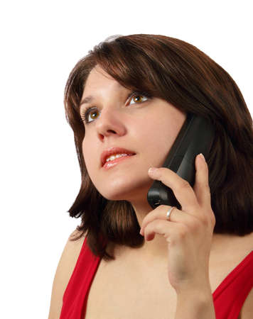 Attractive brunette talking on cell phone and looking up isolated on white backgroundの写真素材
