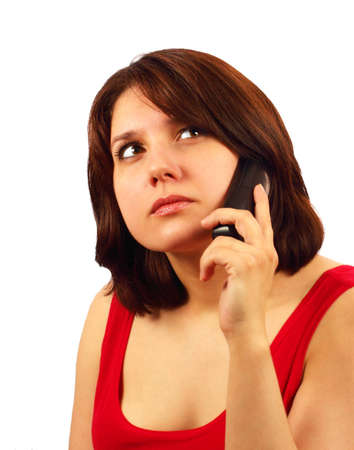 Attractive brunette talking on cell phone and thinking isolated on white backgroundの写真素材