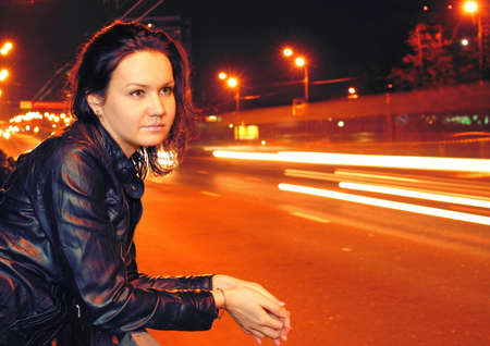 Beautiful young woman in night cityの写真素材