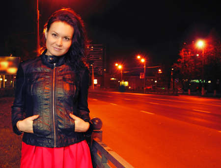 Beautiful young woman in night cityの写真素材