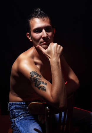 Sitting macho man on black backgroundの写真素材