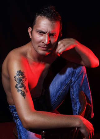 Sitting macho man on black backgroundの写真素材