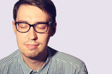 Funny young man wearing glasses with closed eyesの写真素材