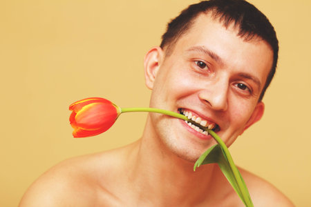 Romantic smiling young man with flowersの写真素材