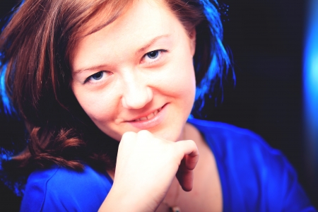 Portrait of beautiful brunette girl on dark backgroundの写真素材