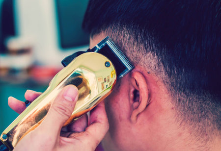 Close up of barber cutting hair with hair clipper