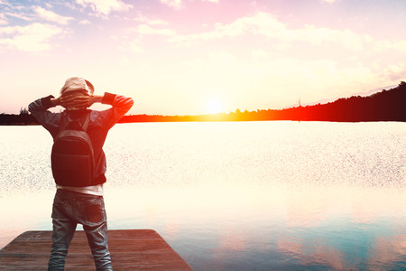 Happy man traveler standing at beautiful lagoon and feel relaxing at sunset time,travel conceptの写真素材