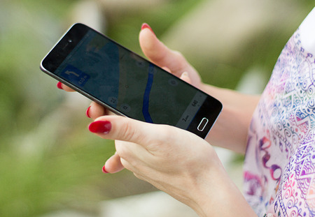 Woman looking the best way to location with a navigator in a phoneの写真素材