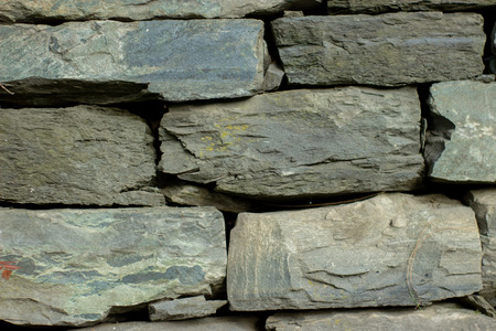Dark grey block rocks textured wall facade.の写真素材