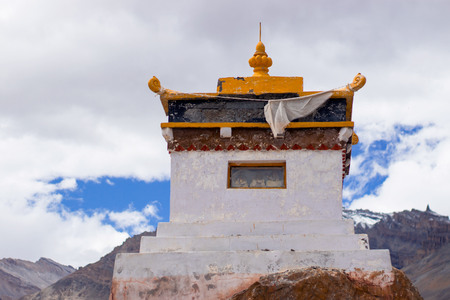 A small Tibetan monastery in the mountains with Buddha figurines inside.