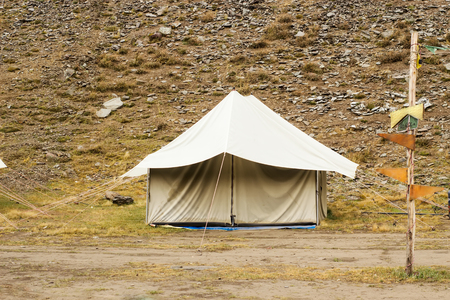 Tourist tents in a trekking camping up in a mountains with green and rocks background.の写真素材
