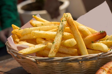 Crispy tasty seasoned french fries in a basketの写真素材