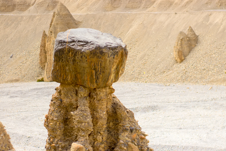 Strange figures formed from sand in the desert in the mountains of India. Huge stone on top.の写真素材