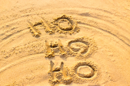 Handwriting Santa Claus's Ho Ho Ho on the sand. Christmas conceptの写真素材