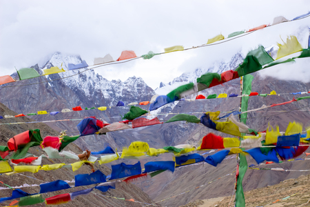 Tibetan flags with snow peaks on background. Scare away evil spirits.の写真素材