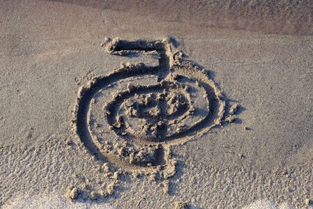 Healing symbol of Cho ku Rei drawn finger on sand for alternative healing with the help light energy Reiki. Can be used to increase the flow of energy or to accelerate something.の写真素材