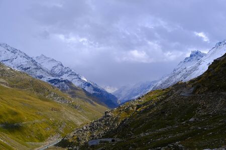 Beautiful view of the mountains covered with greenery and snow-capped peaks between which the river flows and winds the road. Travelling and trekking in the Himalayan mountains in India.の写真素材