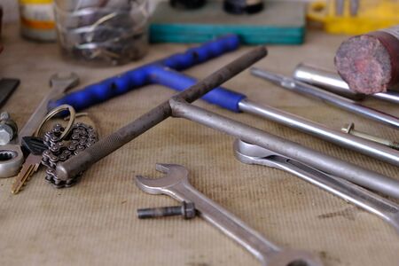 A set of repair tools lie on a cardboard surface with a key from the vehicle with a keychain in the form of a chain. Metal and steel objects.の写真素材
