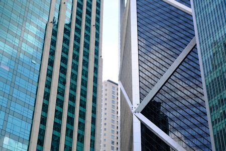 Part of high multi-storey buildings made of metal and glass that reflect the sky. Windows of a big city.の写真素材