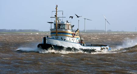Tugboat crossing the storm, at his way to the safe harborの写真素材