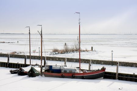 Fishing ship enclosed by ice in Dutch harborの写真素材
