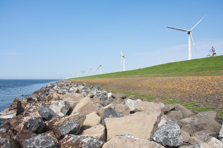 Endless dike with windmills with lonely bicycle in the Netherlandsの写真素材