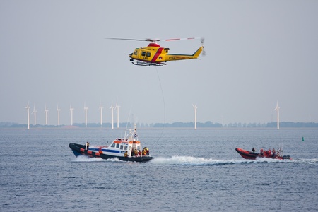 URK, THE NETHERLANDS - JUN 7 2011: The lifeboat of Urk is practicing with a rescue helicopter of the Dutch Royal Airforce in the IJssellake near Urkのeditorial素材