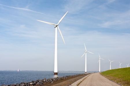 Wind turbines standing along the dyke in the Dutch seaの写真素材