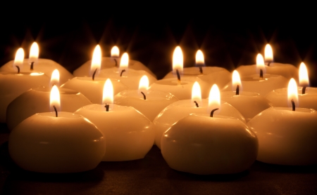 Group of burning candles at a black backgroundの写真素材