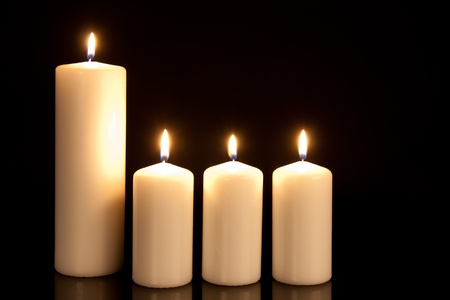 Four white candles on blackの写真素材