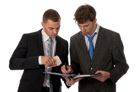 Businessman signing a contract. The deal is payed in cash money. Isolated on whiteの写真素材