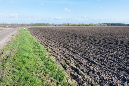 Country road in the Netherlands with bare farmlandの写真素材