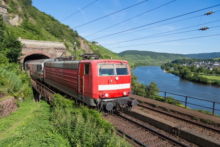 Train leaving a tunnel near the river Moselle in Germanyの写真素材