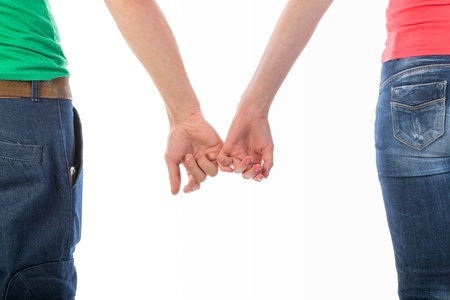 Cropped rear view image of a man and woman in casual clothing holding hands isolated on whiteの写真素材