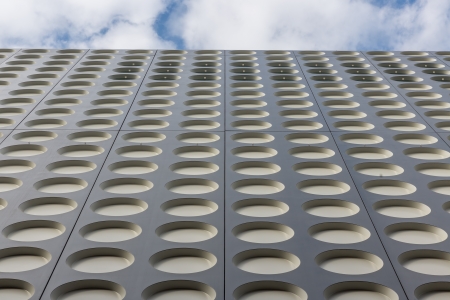 Facade with a symmetrical pattern of a modern office buildingの写真素材