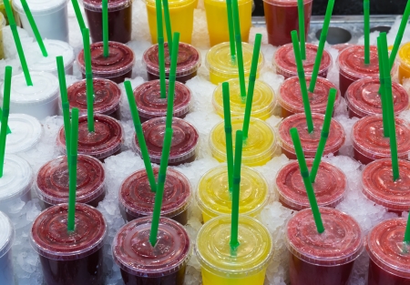 Fresh juices with straws at a market in Barcelonaの写真素材
