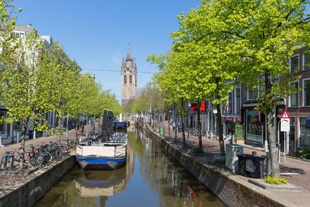 DELFT, THE NETHERLANDS - APRIL 16 Townscape with unknown people from the center of Delft with a canal and old historic town houses on April 16, 2014 in the city of Delft, the Netherlandsのeditorial素材
