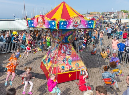 URK, THE NETHERLANDS - APR 26  Unknown children have fun in a carousel at a national holiday at the harbor of Urk on April 26, 2014, the Netherlandsのeditorial素材