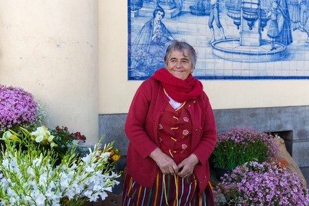 FUNCHAL, PORTUGAL - MAY 02  A traditional woman sells flowers at the famous Mercado dos Lavradores on May 02, 2014 at Funchal, capital city of Madeira, Portugalのeditorial素材